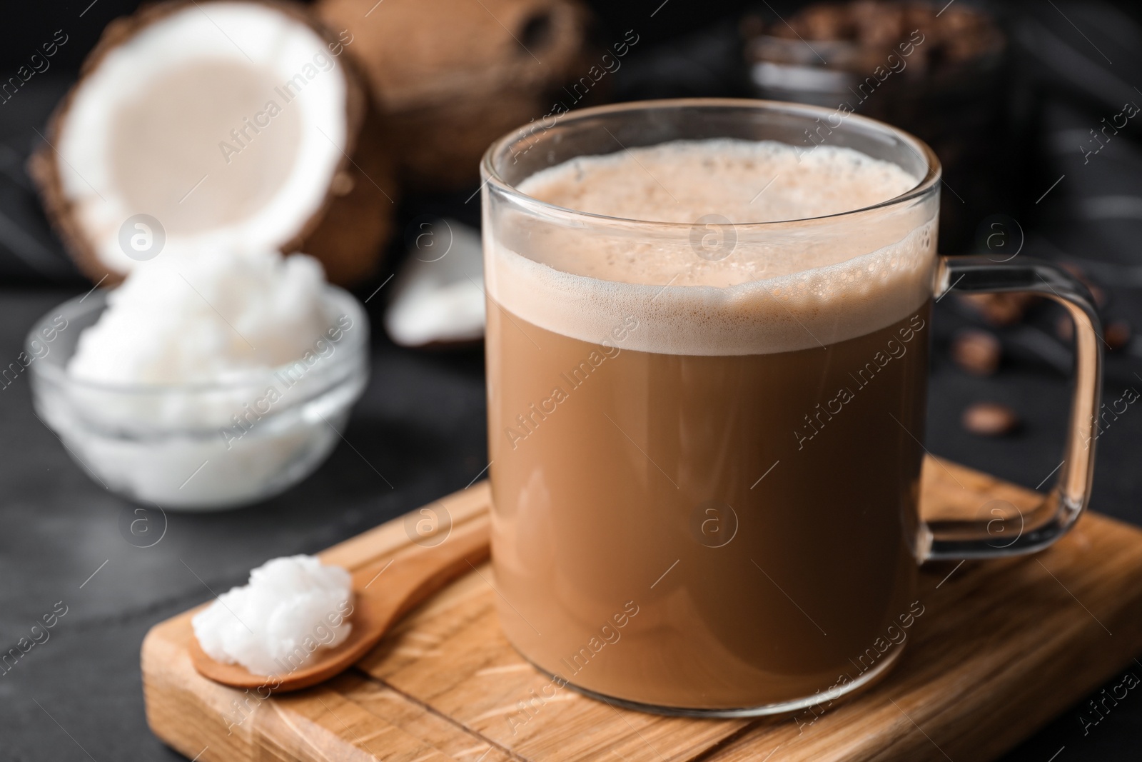 Photo of Delicious coffee with organic coconut oil on grey table