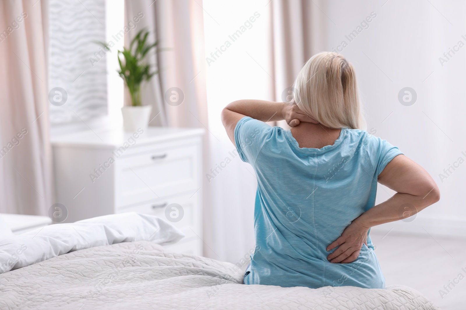 Photo of Senior woman suffering from back pain at home