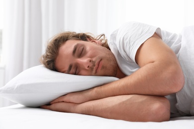 Handsome young man sleeping on pillow at home. Bedtime