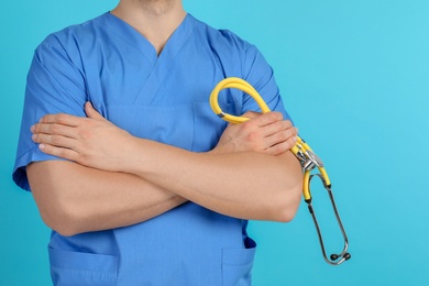 Medical assistant with stethoscope on color background, closeup