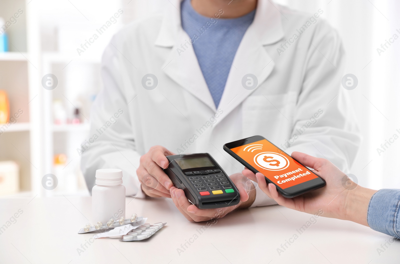 Image of Woman using terminal for contactless payment with smartphone in pharmacy, closeup. Transaction completed screen on device