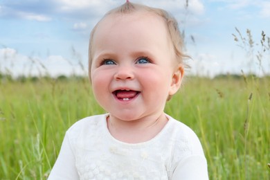 Portrait of adorable little baby in green field