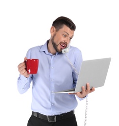 Portrait of businessman holding cup and laptop while talking on phone against white background