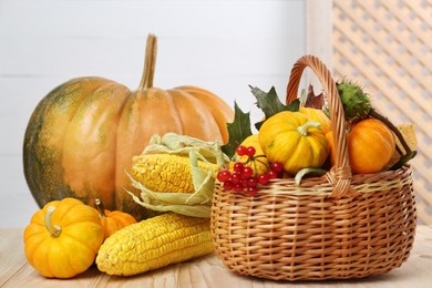 Photo of Happy Thanksgiving day. Composition with pumpkins, corn cobs and berries on wooden table