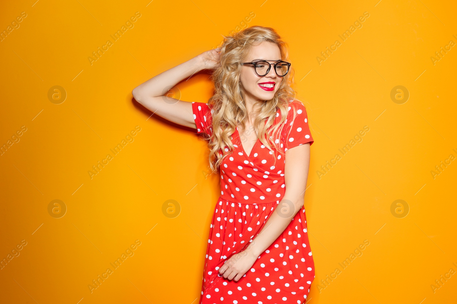Photo of Stylish young woman with glasses posing on color background