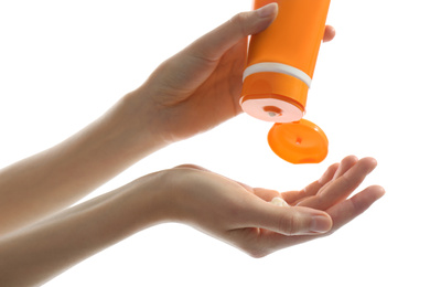 Woman applying sun protection cream on hand against white background, closeup