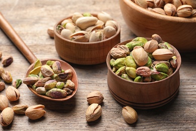 Photo of Composition with organic pistachio nuts on wooden table