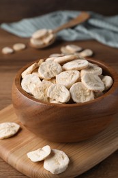 Photo of Bowl with dried banana slices on wooden table, closeup