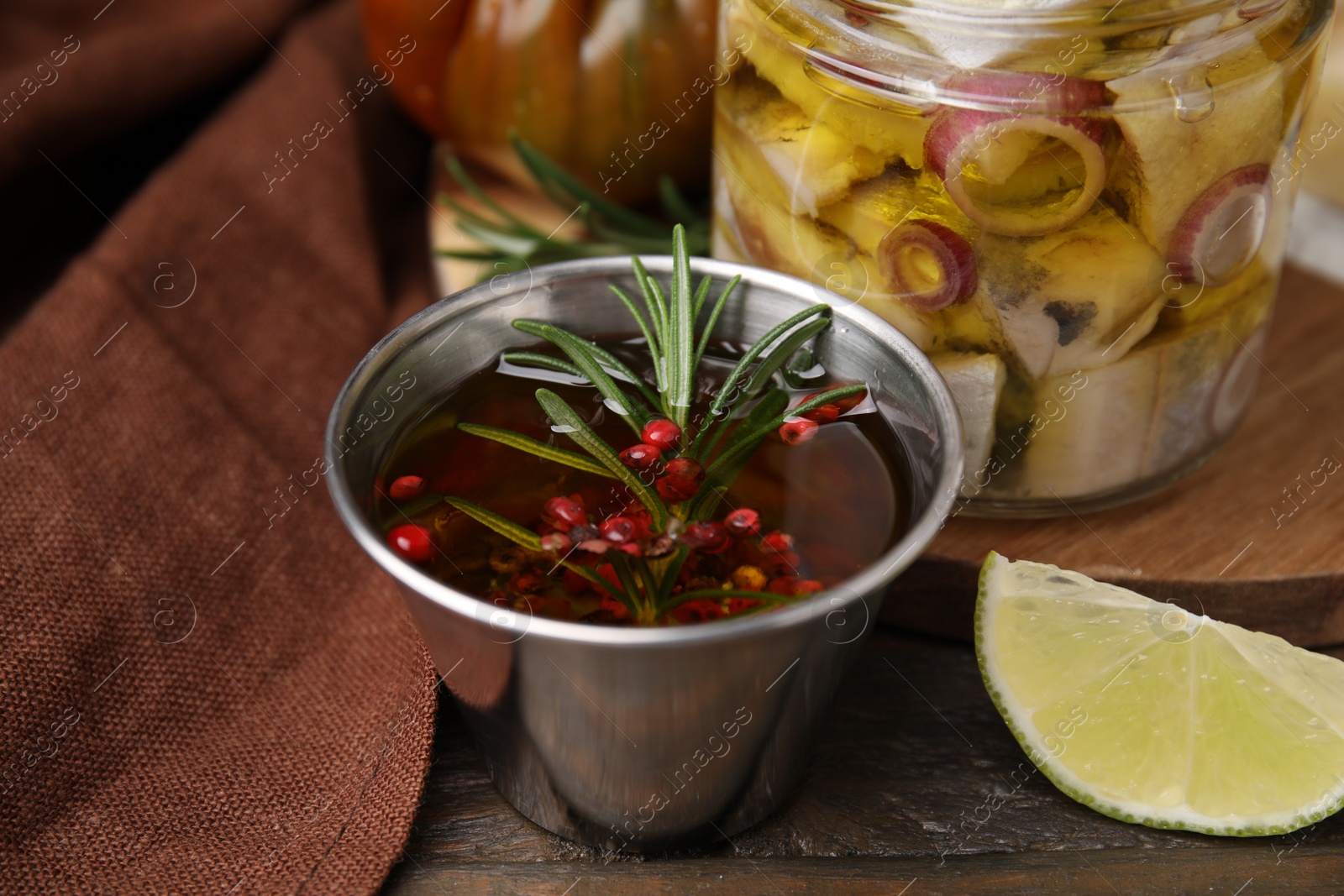 Photo of Tasty fish marinade with rosemary in bowl on wooden table, closeup