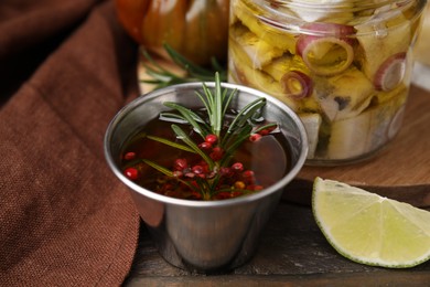 Photo of Tasty fish marinade with rosemary in bowl on wooden table, closeup