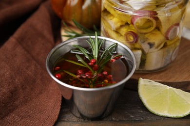 Tasty fish marinade with rosemary in bowl on wooden table, closeup