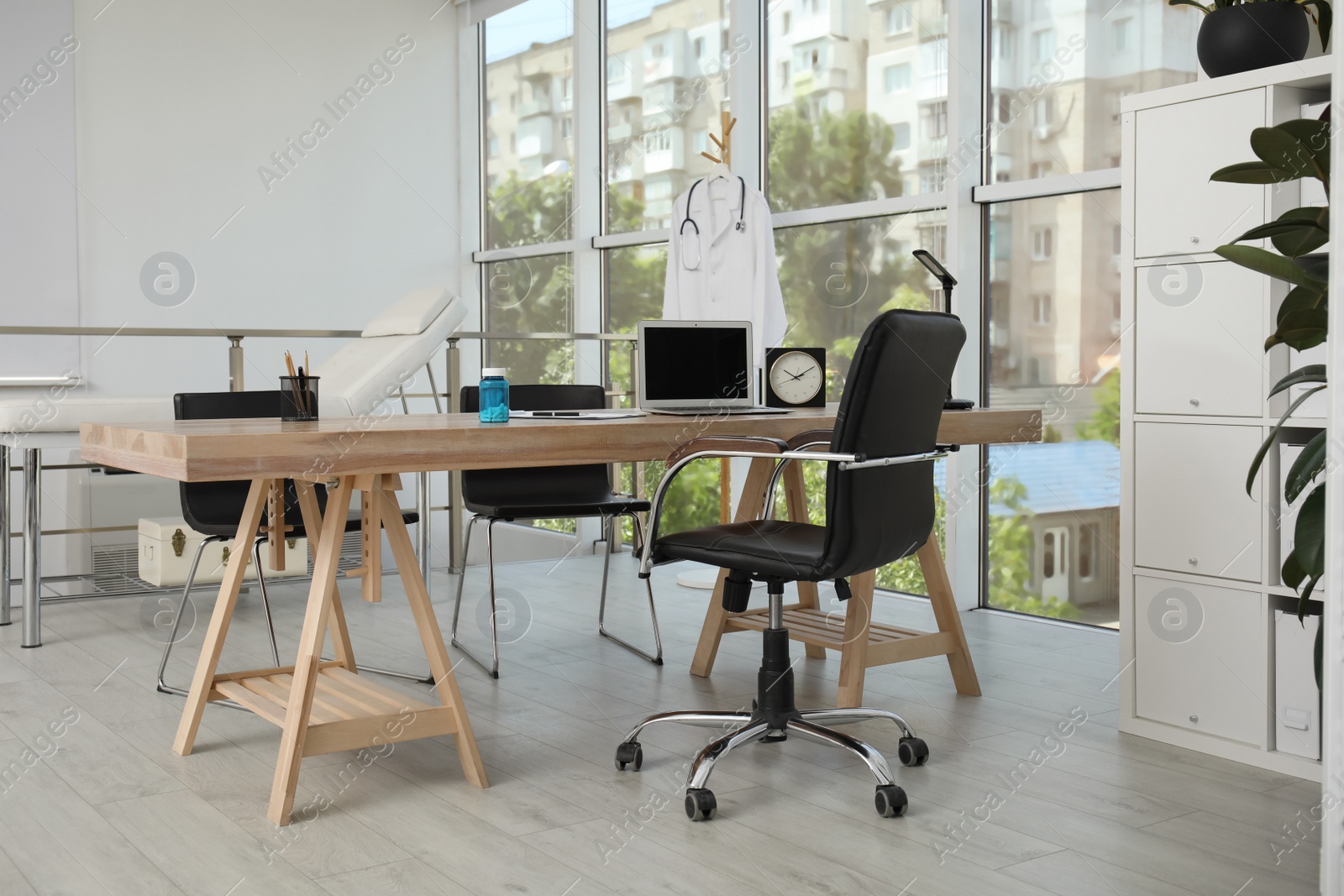 Photo of Modern medical office interior with doctor's workplace near window