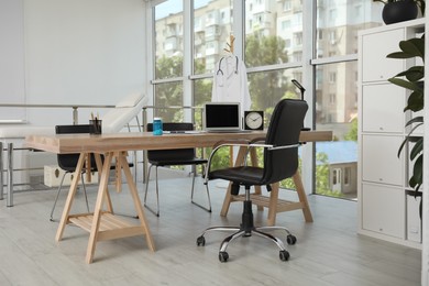 Modern medical office interior with doctor's workplace near window