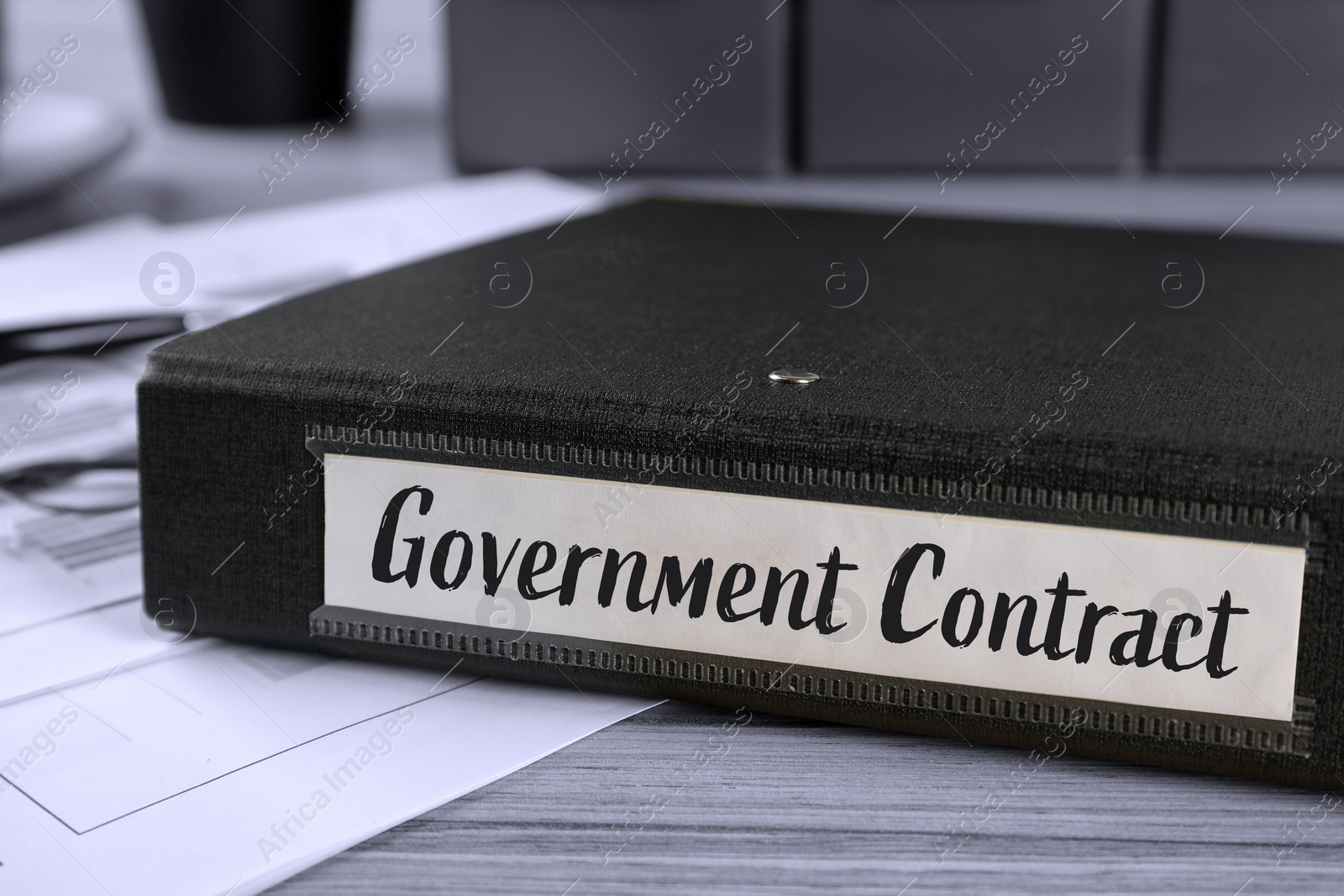 Image of Black folder with Government Contract label on desk in office, closeup