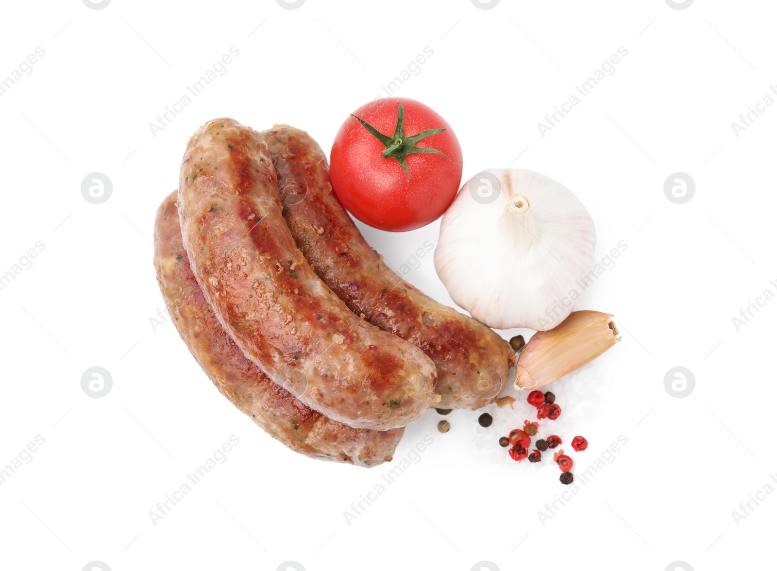 Photo of Tasty homemade sausages, peppercorns, tomato and garlic isolated on white, top view