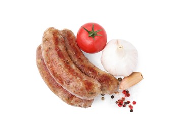 Photo of Tasty homemade sausages, peppercorns, tomato and garlic isolated on white, top view