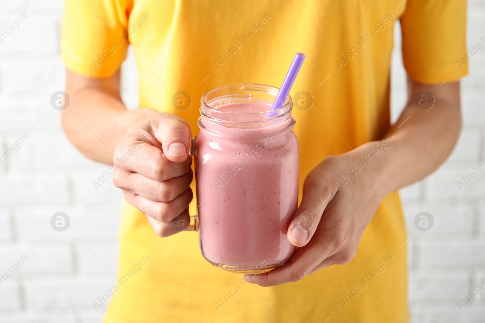 Image of Woman with mason jar of tasty smoothie, closeup