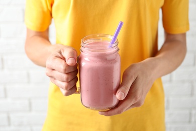 Woman with mason jar of tasty smoothie, closeup