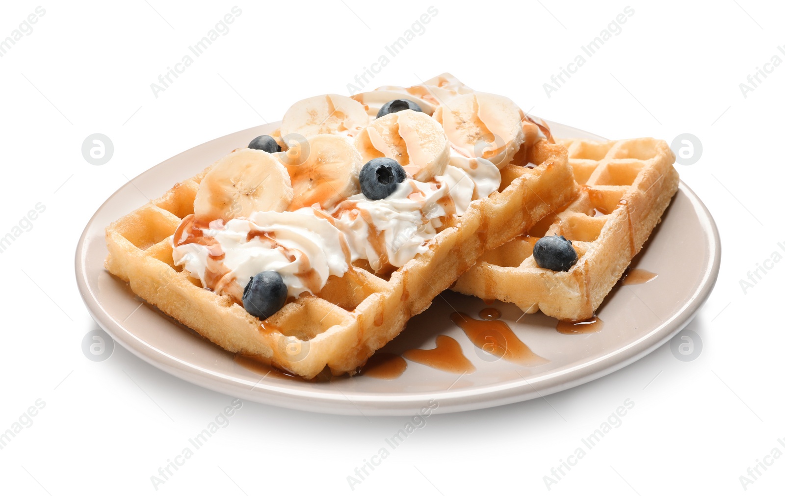 Photo of Plate with yummy waffles, whipped cream, blueberries and banana on white background