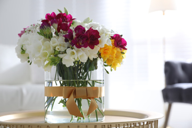 Photo of Beautiful bouquet with spring freesia flowers in light room. Space for text