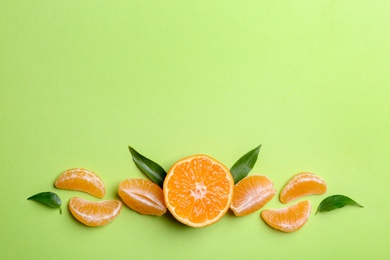 Photo of Composition with tangerine and leaves on color background, flat lay. Space for text