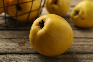 Photo of Tasty ripe quinces on wooden table, closeup