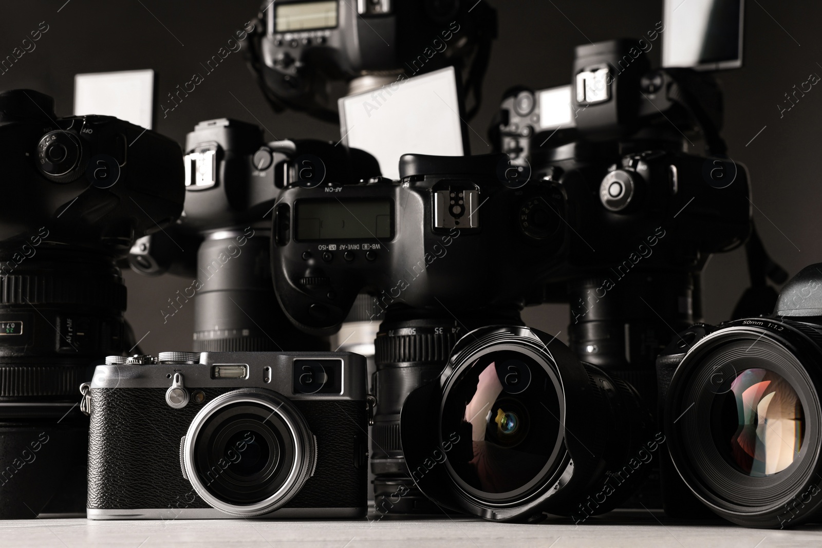 Photo of Modern cameras on white table, closeup. Professional photography equipment