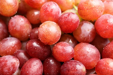 Photo of Fresh ripe juicy pink grapes as background, closeup view