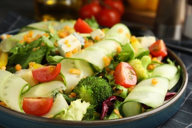 Delicious salad with lentils, vegetables and cheese on table, closeup