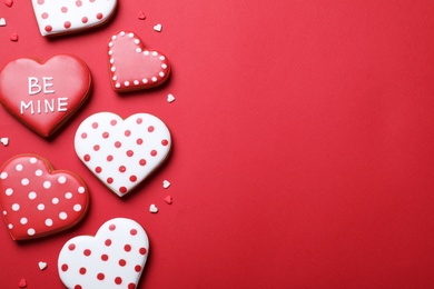 Photo of Valentine's day cookies on red background, flat lay. Space for text