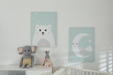 Stylish baby room interior with cute pictures on white wall