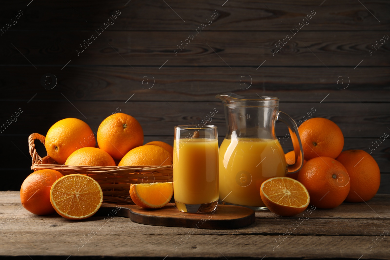 Photo of Tasty fresh oranges and juice on wooden table