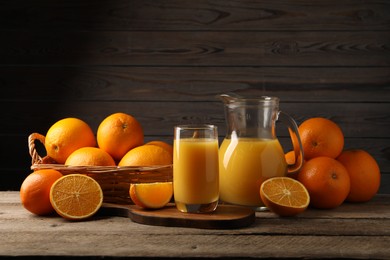 Tasty fresh oranges and juice on wooden table