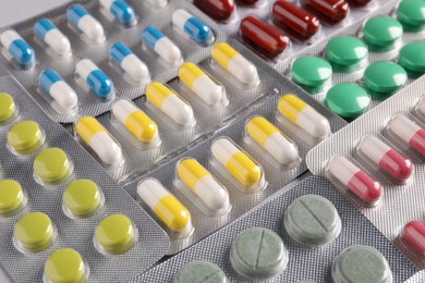 Many blisters with different pills as background, closeup