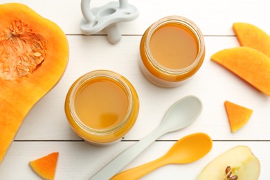 Tasty baby food in jars, pacifier and ingredients on white wooden table, flat lay