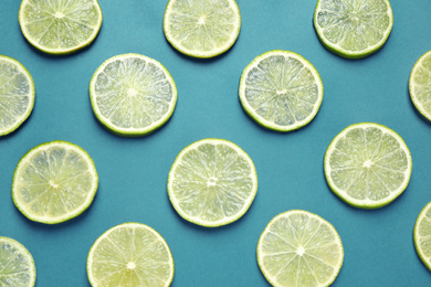 Juicy fresh lime slices on blue background, flat lay