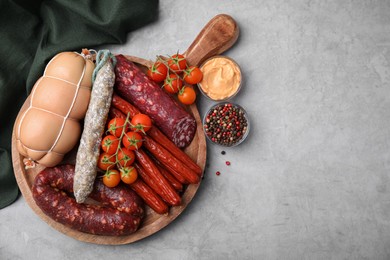 Different types of tasty sausages and ingredients on light grey table, flat lay. Space for text