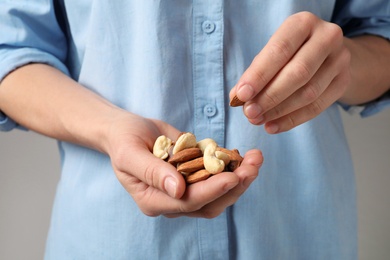Photo of Woman holding organic mixed nuts, closeup. Healthy snack