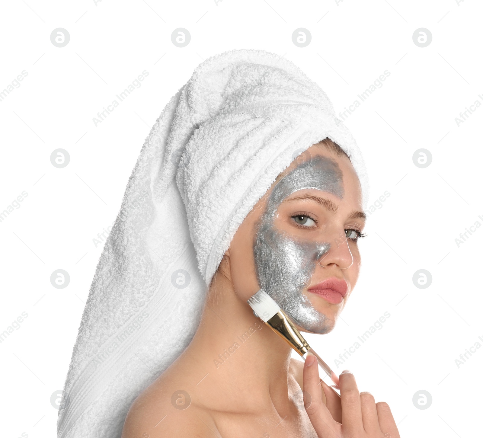 Photo of Beautiful woman applying silver mask on her face against white background