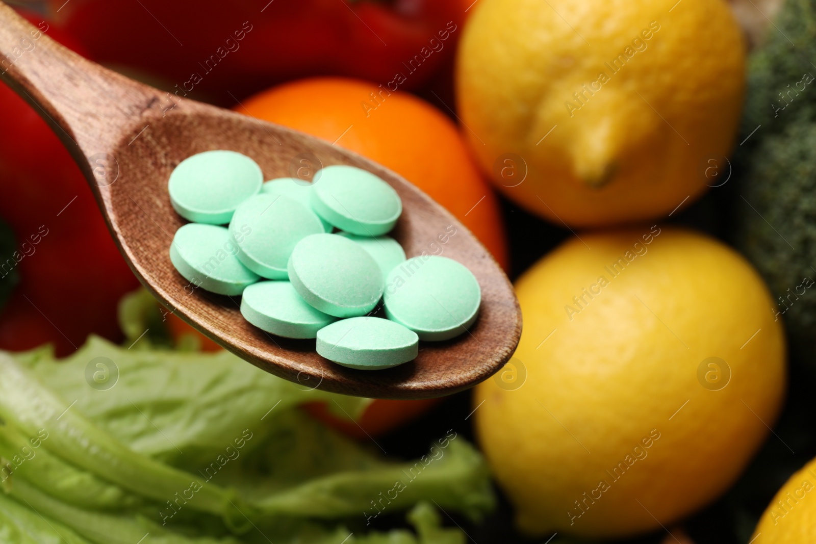 Photo of Dietary supplements. Spoon with pills over food products, closeup