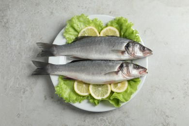 Tasty sea bass fish on grey textured table, top view