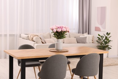 Photo of Table, chairs and vase with peonies in stylish dining room