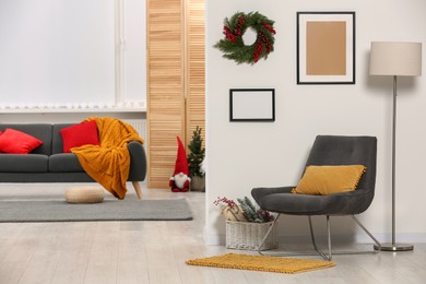 Photo of Comfortable furniture in stylish room decorated for Christmas. Interior design