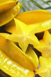 Delicious carambola fruits and slices on table
