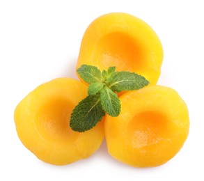 Sweet canned peach halves with mint isolated on white, top view
