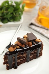 Photo of Piece of tasty homemade chocolate cake with nuts on plate, closeup