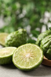 Photo of Fresh ripe bergamot fruits on light grey table against blurred background, closeup. Space for text