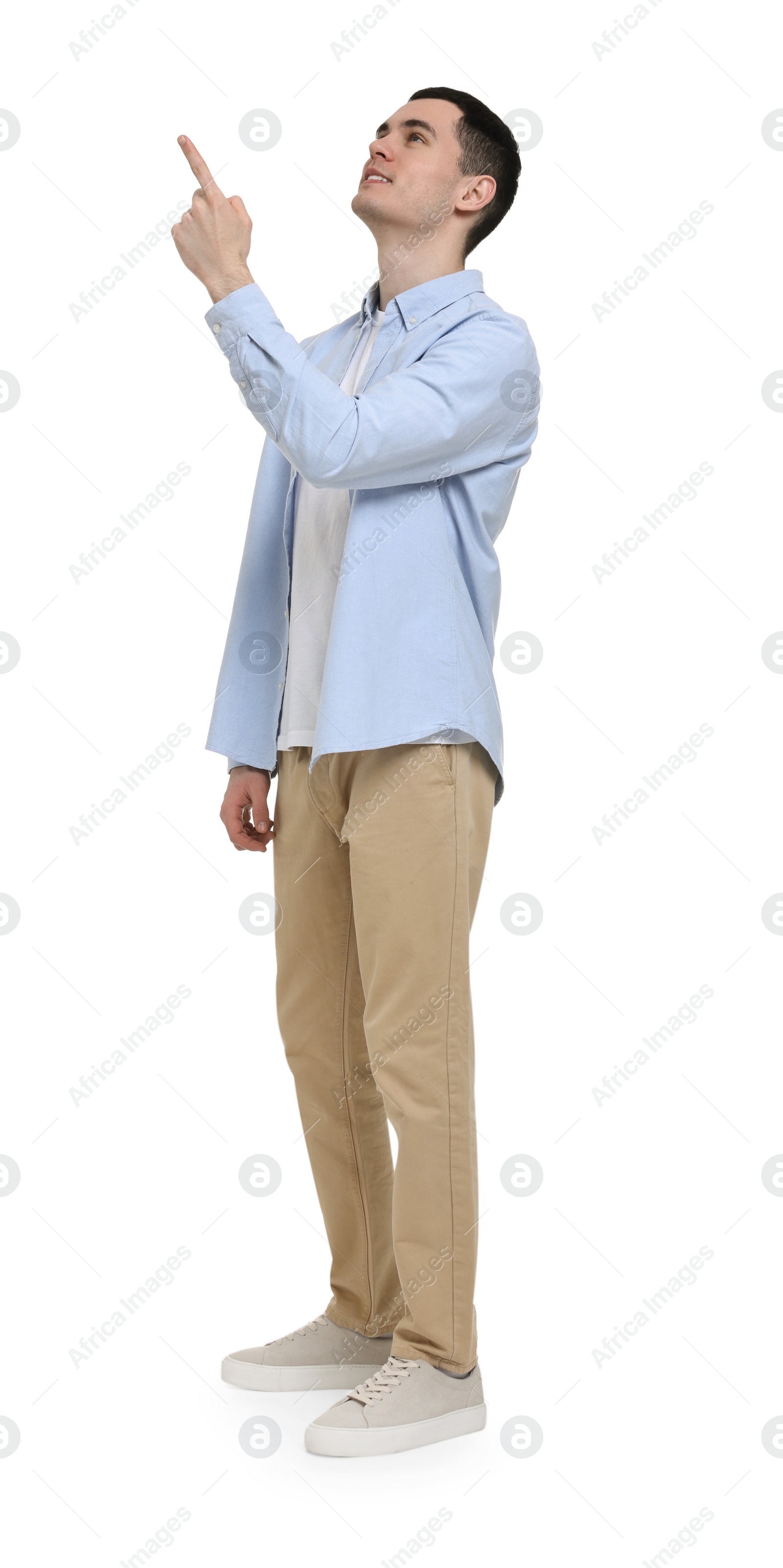 Photo of Young man pointing at something on white background