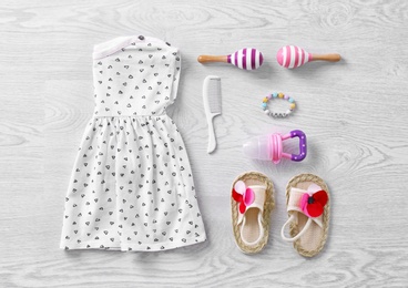 Photo of Set of baby clothes and accessories on wooden background, flat lay
