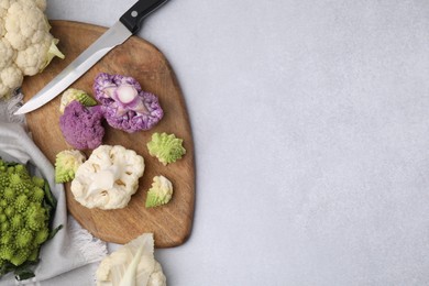 Various cauliflower cabbages on light grey table, flat lay. Space for text